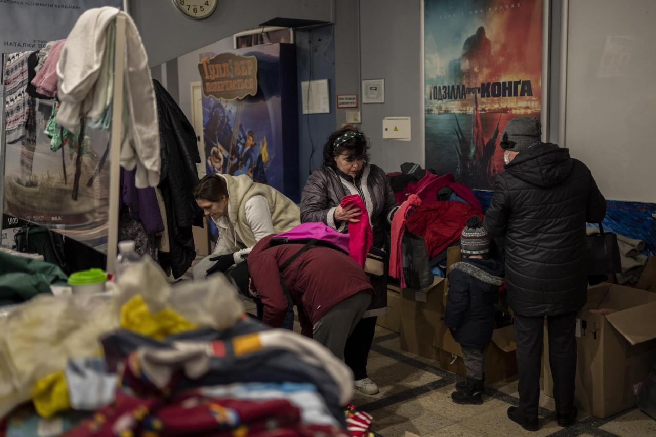 Ukrainians pick clothes inside a cinema turned aid center in Lviv, western Ukraine, Saturday, March 12, 2022. (AP Photo/Bernat Armangue)