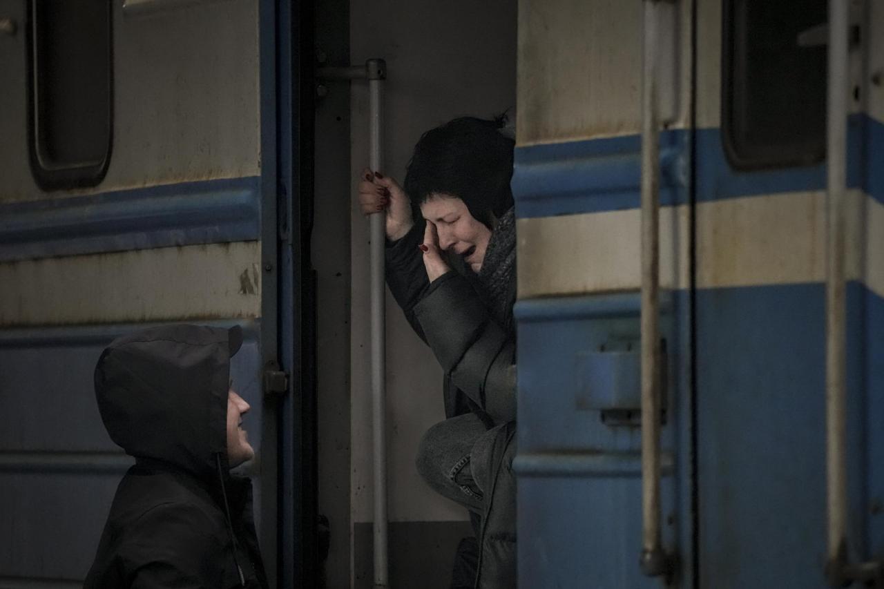 A woman on a Lviv bound train cries while she bids goodbye to a man in Kyiv, Ukraine, Saturday, March 12, 2022. (AP Photo/Vadim Ghirda)