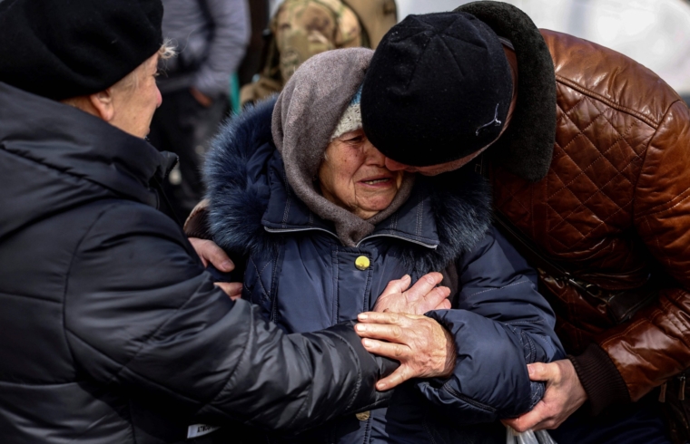 A woman is comforted as she cries in Kyiv after fleeing her home in the outskirts of the city on March 28, 2022, amid Russian invasion of Ukraine. (Photo by RONALDO SCHEMIDT / AFP) (Photo by RONALDO SCHEMIDT/AFP via Getty Images)