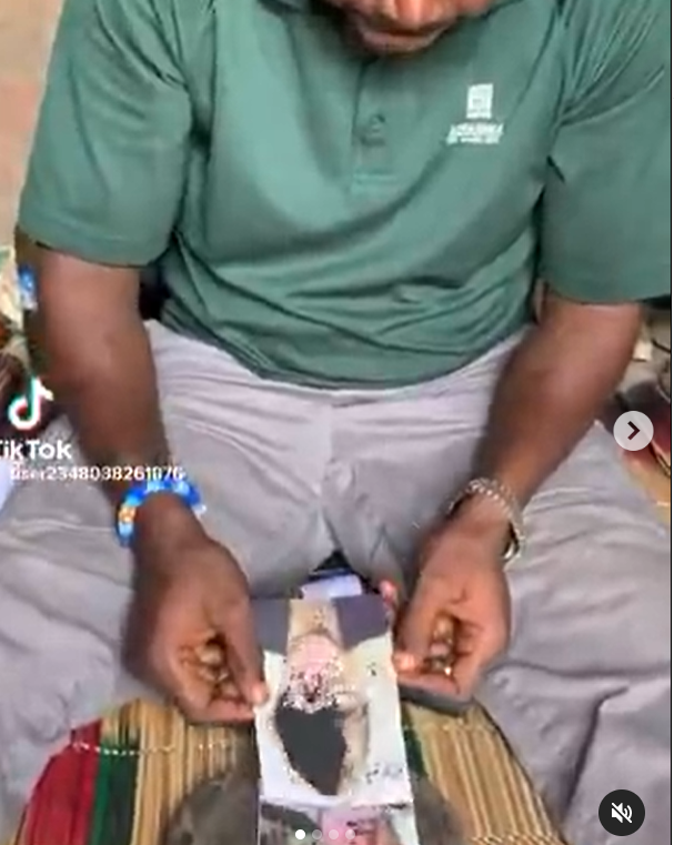 Native doctor shares video of him tying up pictures of a white woman and a white man for a client (video)